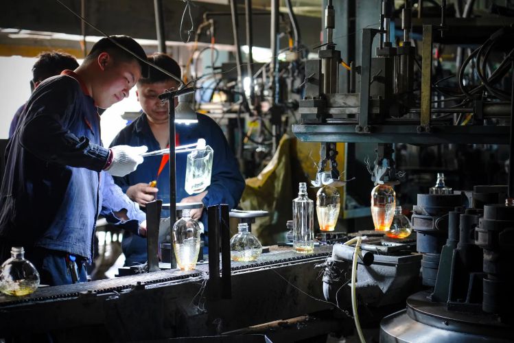 productie van grote glazen flessen